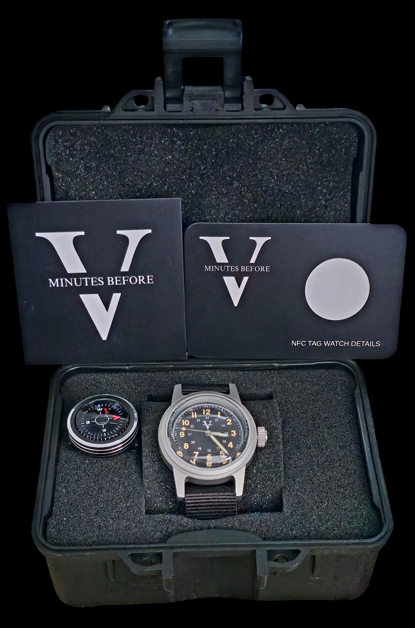 The NORMANDY (Field watch 36mm) by Five Minutes Before, with a black strap, sits in a foam-lined, open black box. Accompanied by an adventurers compass, an NFC tag card, and a Minutes Before booklet featuring a V, it perfectly blends utility and style for field watch enthusiasts.